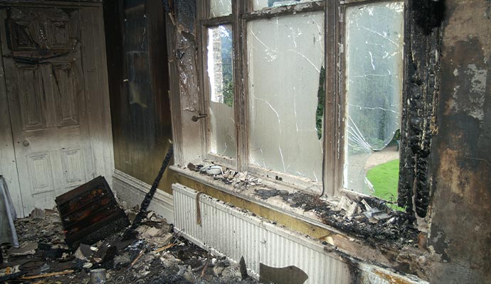 Fire damaged house and broken window glass