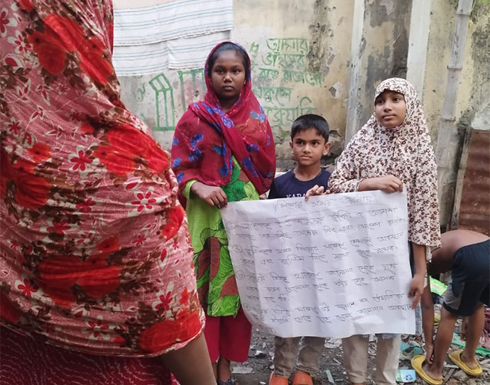 Abdullah stands with an earthquake awareness banner